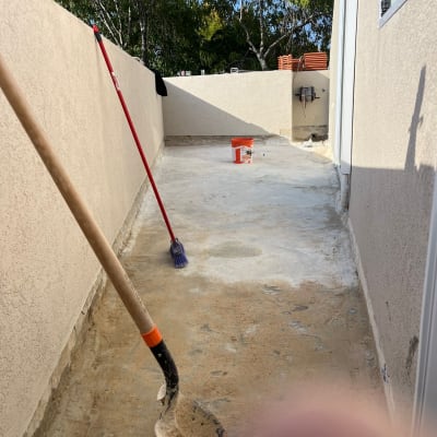 את חפירה ומטאטא על רצפת בטון עם דלי כתום