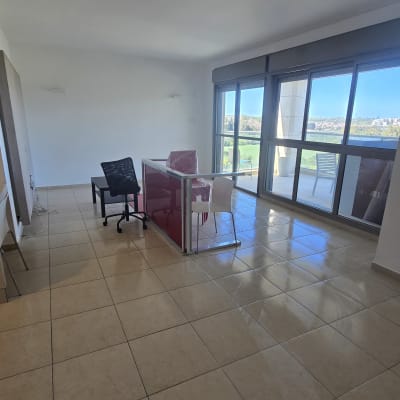 חדר ריק עם שולחן וכיסאות ליד חלון גדול