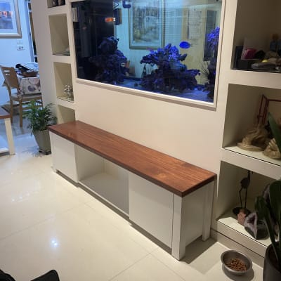 ספסל עץ לבן עם משטח עץ, ליד אקווריום גדול