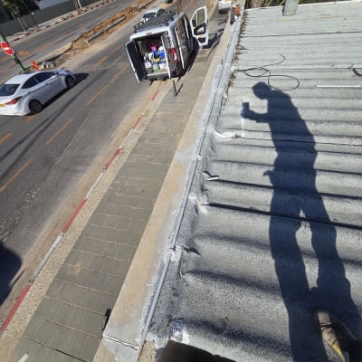 עבודת איטום על גג עם צל של אדם