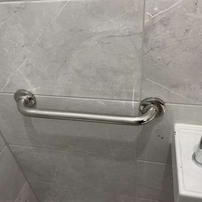 ידית אחיזה מותקנת על קיר אריחים בחדר אמבטיה