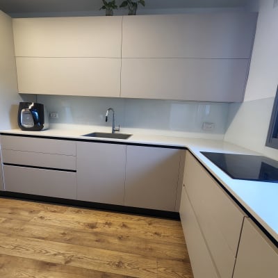 מטבח עם חיפוי זכוכית לבן מעל הכיור