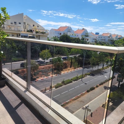 מעקה זכוכית במרפסת עם נוף לעיר