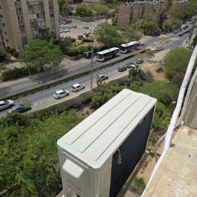 יחידת מיזוג אוויר חיצונית מותקנת על קיר בניין
