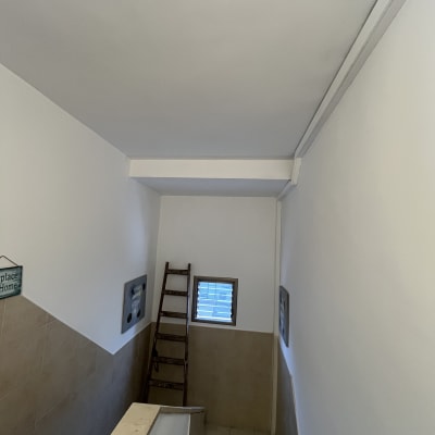 קירות צבועים בלבן עם סולם בחדר מדרגות