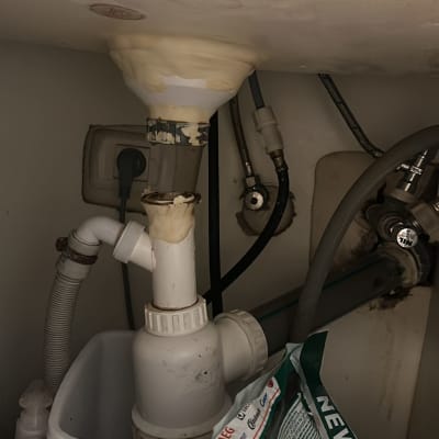 צנרת פלסטיק מתחת לכיור עם חיבורים ותיקונים