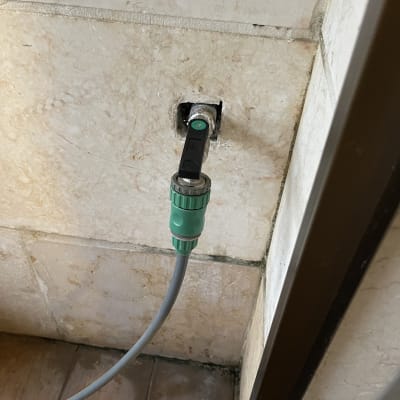 ברז מים עם צינור מחובר לקיר