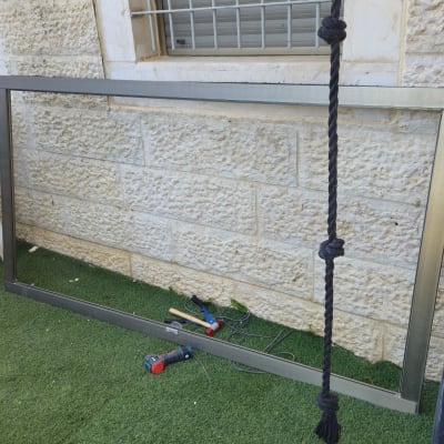 מסגרת מתכת וכלים ליד קיר אבן