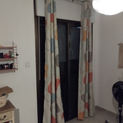 תריסים חומים מאחורי וילונות צבעוניים