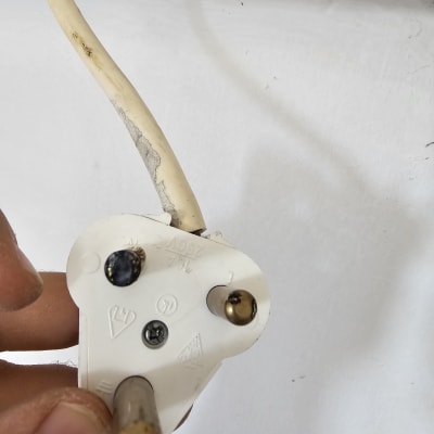 תקע חשמלי לבן עם שלושה פינים מוזהבים