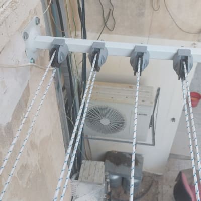 מתקן כביסה עם חבלים ומחברים על קיר חיצוני