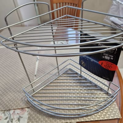 מדף מתכת פינתי עם ברגים על שולחן עץ