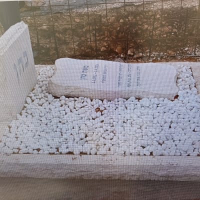 מצבה עם כיתוב ואבנים לבנות מסביב