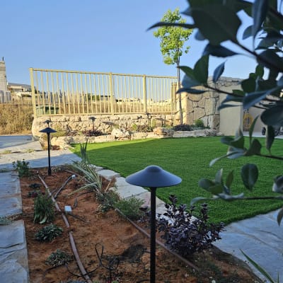 ערוגת פרחים עם תאורת גן ודשא ירוק