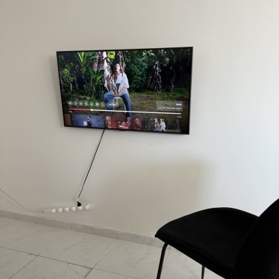 טלוויזיה מותקנת על קיר עם כבל חשמל גלוי