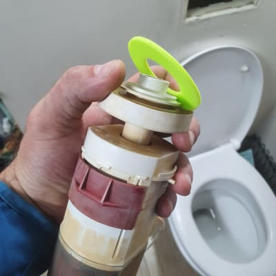 יד מחזיקה חלק פלסטיק ליד אסלה בשירותים