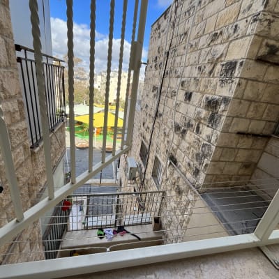 מעקה מתכת עם חוטי כביסה ומתקן תלייה