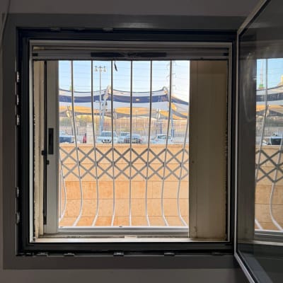 חלון פתוח עם סורגים ונוף חיצוני