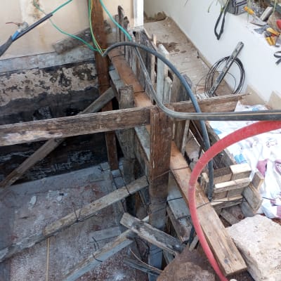 עבודות איטום עם קרשים וצינורות באתר בנייה