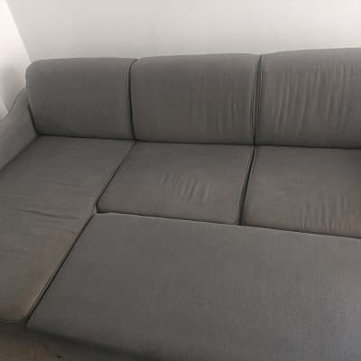 ספה אפורה בחדר עם קיר לבן
