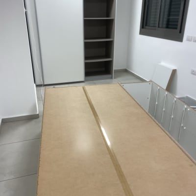 חלקי רהיטים מפורקים על הרצפה בחדר ריק