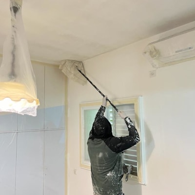 אדם צובע תקרה עם רולר צבע