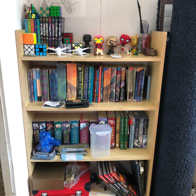 מדף ספרים עם קוביות רוביק ודמויות פופ