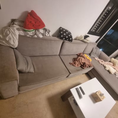 ספה אפורה עם כריות ושמיכות