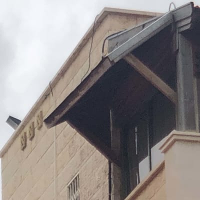 גג עם מרזב מתכת וכבלים חשמליים