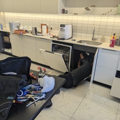 אדם מתקן מדיח כלים עם כלים על שולחן