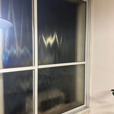 חלון זכוכית עם מסגרת מתכת בחדר פנימי