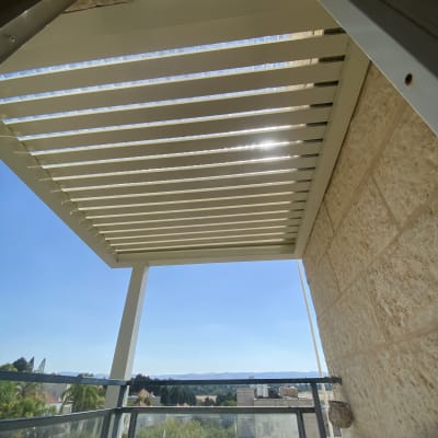 סוכך מתכת עם שלבים אופקיים על מרפסת