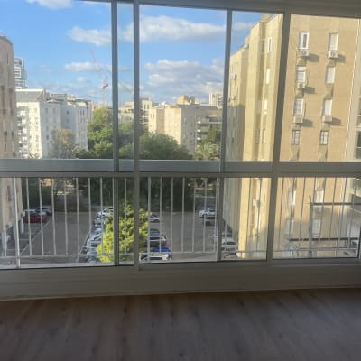 חלונות ויטרינה גדולים ונקיים בדירה המשקיפים לנוף עירוני