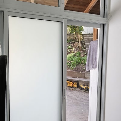 דלת אלומיניום עם זכוכית חלבית וחלון פתוח