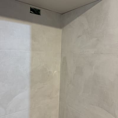 קיר עם אריחים אפורים ופתח חשמלי