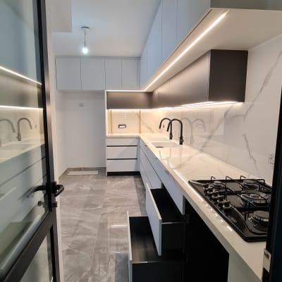 מטבח מודרני עם ארונות לבנים וכיריים גז