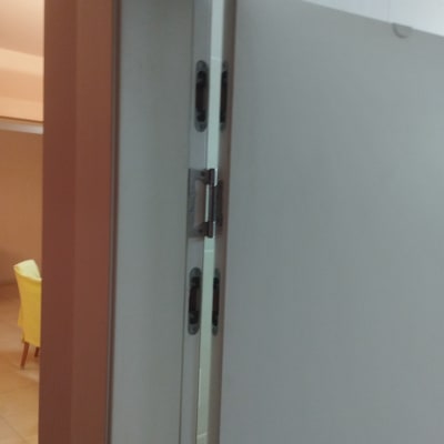 דלת לבנה עם צירים ומנעול מתכת