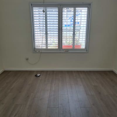 רצפת פרקט עץ כהה בחדר ריק עם חלון