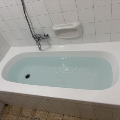 אמבטיה מלאה מים עם ברז ומחזיק סבון