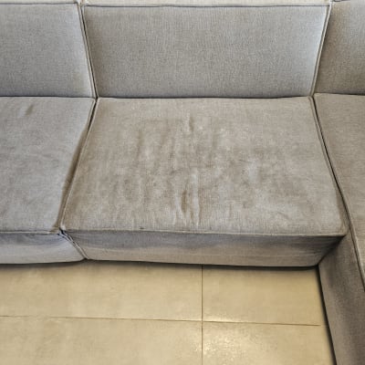 ספה אפורה עם כתמים על המושב המרכזי