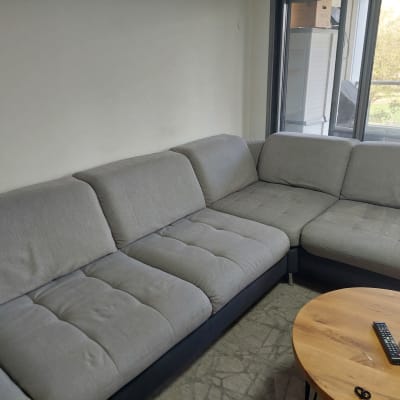 ספה אפורה ליד שולחן עץ קטן עם שלט ואוזניות