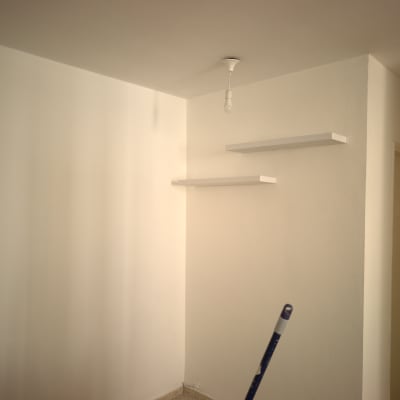 קיר צבוע עם מדפים ומנורה