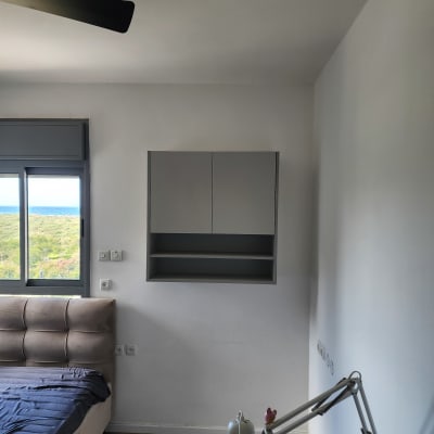 ארון קיר בחדר שינה עם מנורת שולחן