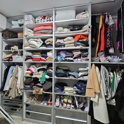 ארון בגדים מאורגן עם מדפים מלאים בבגדים ונעליים