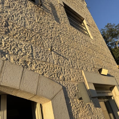 קיר אבן עם חלונות ותאורה חיצונית