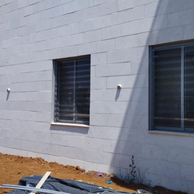 חלונות אלומיניום עם תריסים על קיר חיצוני