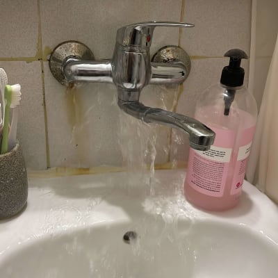 ברז מים זורם בכיור עם סבון נוזלי