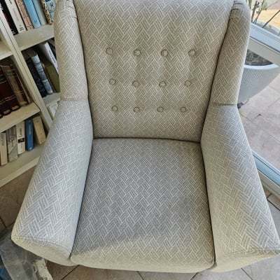 כורסה אפורה ליד מדף ספרים וחלון