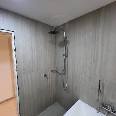 חדר רחצה משופץ מחופה אריחי גרניט פורצלן עם טוש גשם ואמבטיה