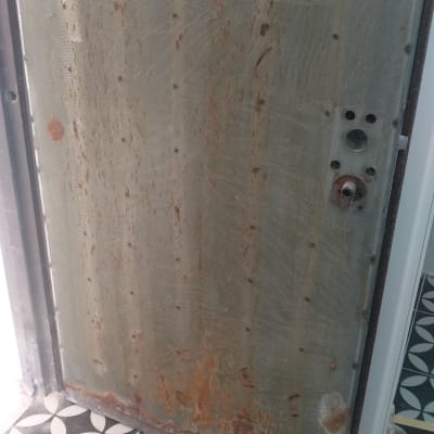 דלת מתכת חלודה עם סימני שחיקה